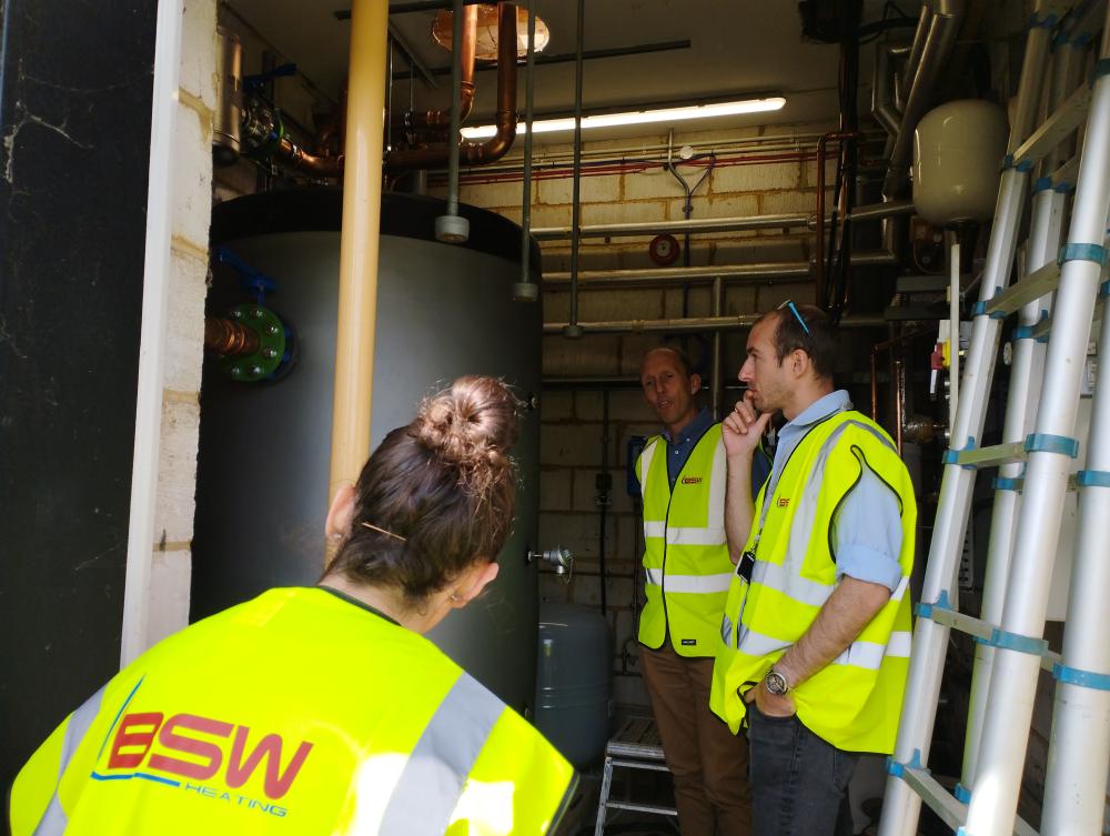 Bradley Davies explaining the buffer vessel in the plant room at Rotherfield